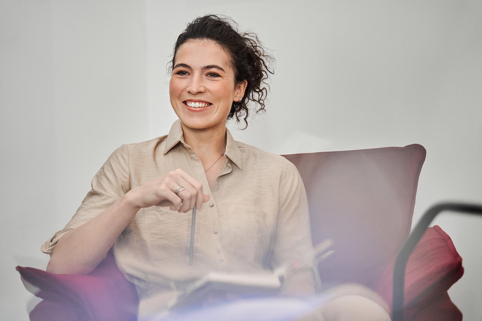 a female psychotherapist sitting in a chair with a smile on her face