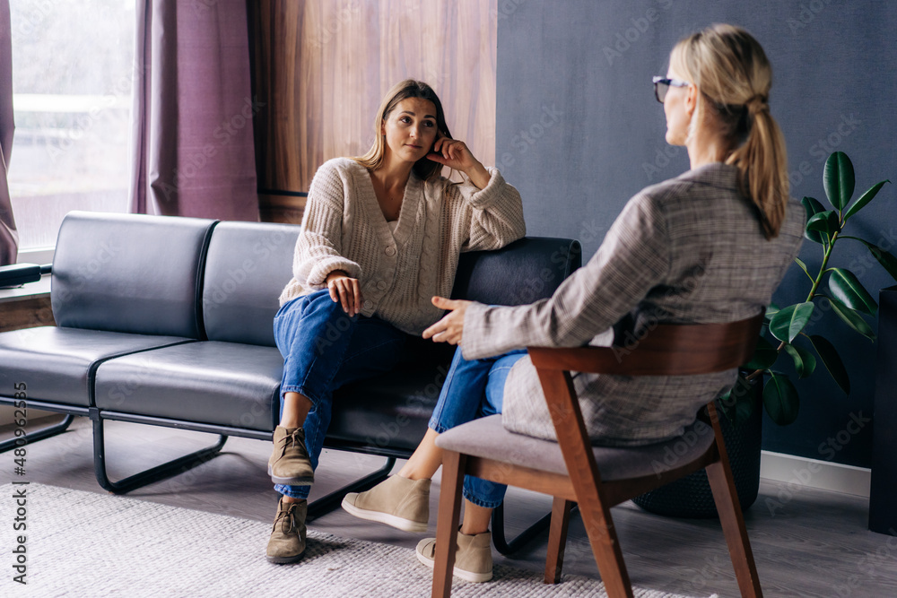 a woman sitting on a sofa having a pyschotheraphy session